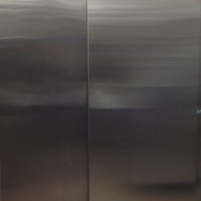 Full-height stainless steel sliding doors with seamless surface and minimal hardware, installed in a Texas facility—engineered for clean aesthetics, durability, and space-efficient access.